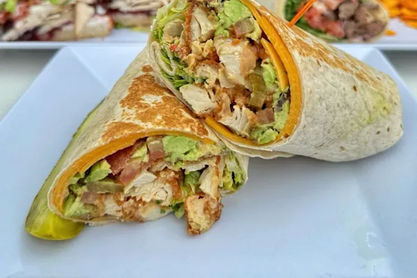 Warm flour tortilla stuffed with panko-battered, antibiotic-free chicken breasts, crispy thick-cut bacon, American yellow cheddar cheese. Layered with freshly sliced avocado, crunchy shredded romaine lettuce, fiery chopped jalapeños, smoky house made chipotle aioli, and sliced tomatoes, this wrap delivers a satisfying kick in every bite.