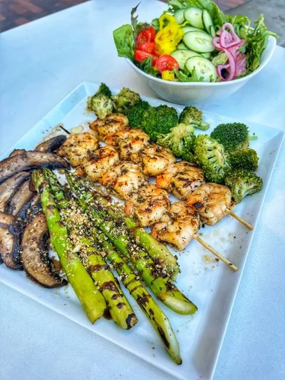 Tantalizingly crispy and flavorful jumbo shrimp marinated in our house garlic sauce spread with garlic cilantro dressing, sauteed fresh broccoli and asparagus, with your choice of soup or house salad