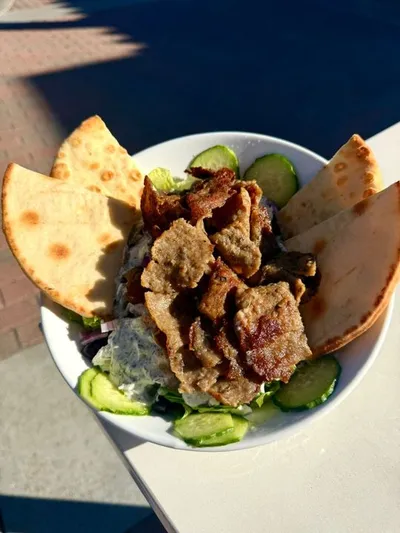 Flame broiled hand-carved gyro with our house made tzatziki sauce, roma tomatoes, thinly sliced red onion, sliced cucumbers, feta cheese, kalamata olives, romaine lettuce with your choice of with your choice of soup or house salad.